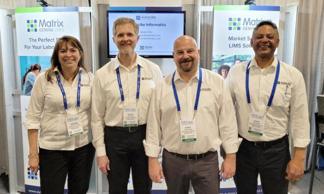 Autoscribe/Xybion staff standing on their booth at PITTCON 2023.